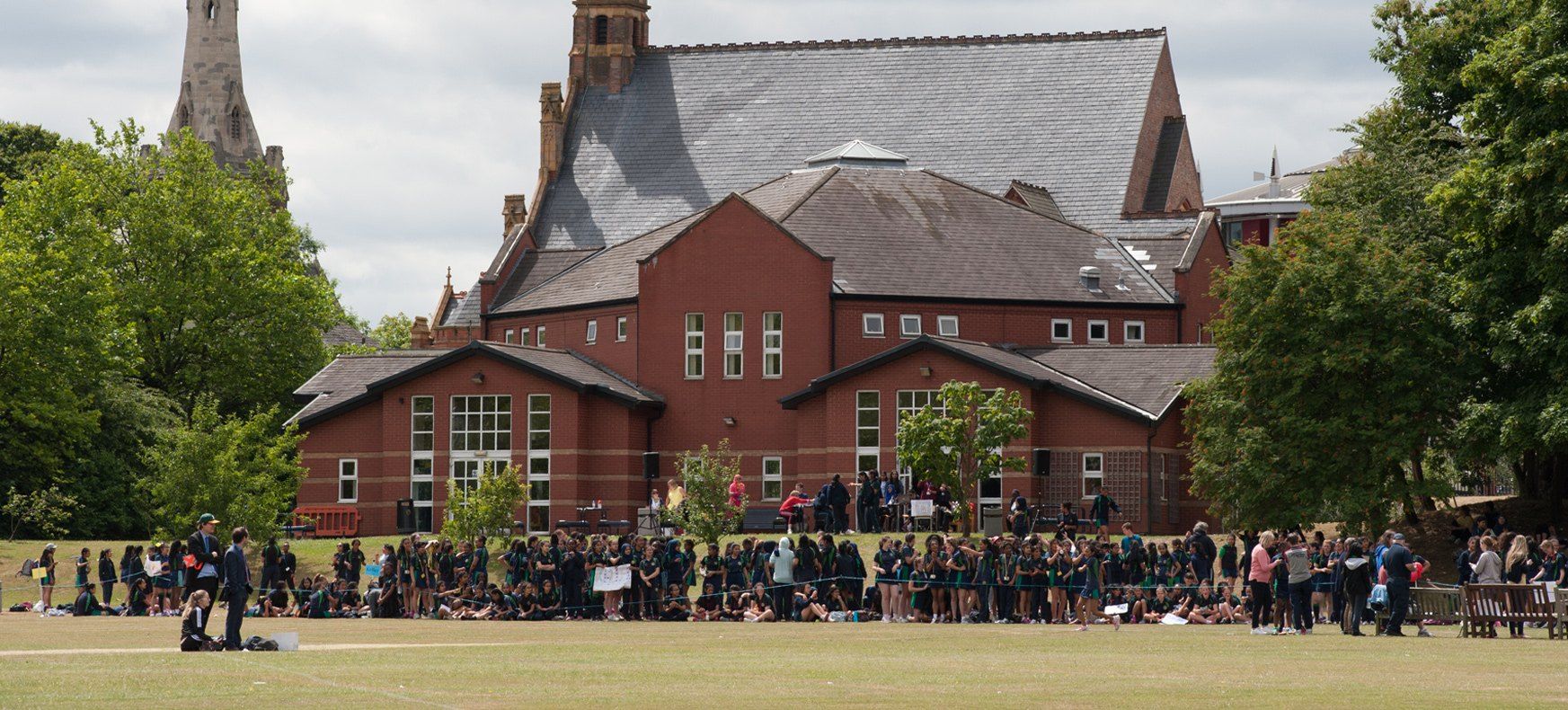 Students and teachers on the playing field outside the main building at KEVI Handsworth School for Girls