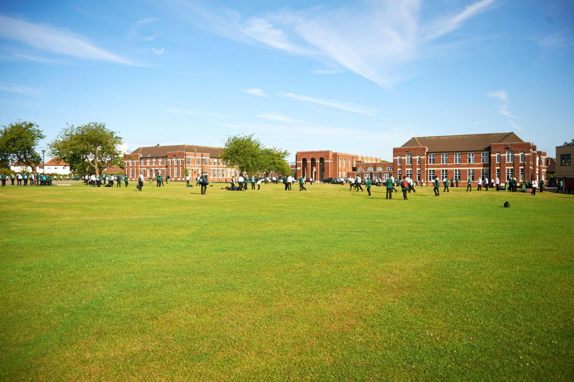 Outside of Southend High School For Boys, brown buildings with large, green grass area