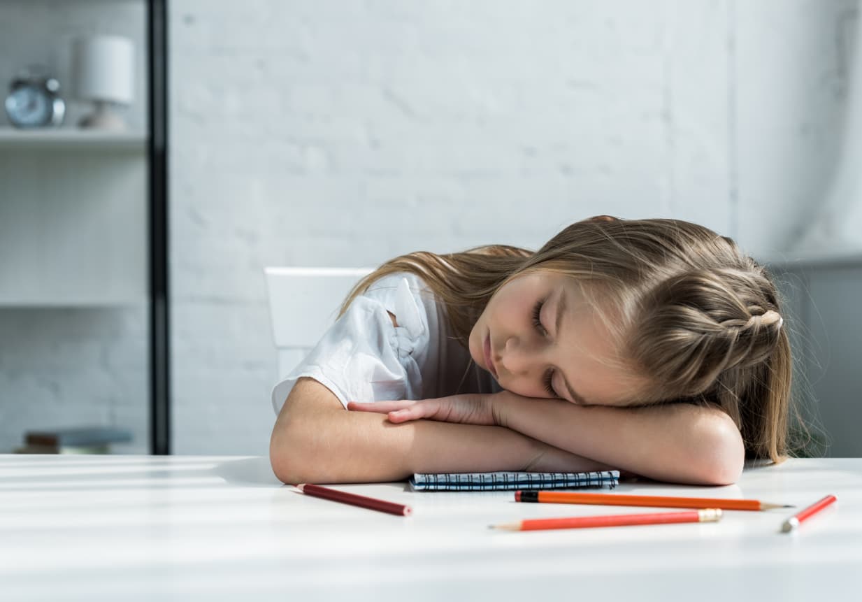 The afternoon slump - a child sleeping at their desk.